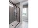 Walk-in shower features modern tile, glass door, and a window for natural light in a neutral color palette at 1170 Holding Village Way, Wake Forest, NC 27587