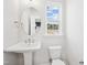 Bright bathroom with pedestal sink, toilet, and window with a view at 1170 Holding Village Way, Wake Forest, NC 27587