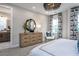 Bright bedroom with a large dresser, stylish mirror, and patterned curtains by the window at 1170 Holding Village Way, Wake Forest, NC 27587