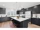 Modern kitchen featuring dark cabinetry, a large island, and stainless steel appliances at 1170 Holding Village Way, Wake Forest, NC 27587