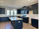 Modern kitchen boasts a stylish island, dark cabinets, stainless appliances, and hardwood flooring at 1170 Holding Village Way, Wake Forest, NC 27587