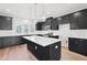 Kitchen with island, white backsplash and dark cabinets, and pendant lighting at 1170 Holding Village Way, Wake Forest, NC 27587