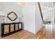 Light-filled entry showcasing hardwood floors, a mirrored cabinet, and a view to the staircase and living area at 1610 Carson St, Raleigh, NC 27608