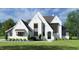 New construction home boasts a light brick facade, dark trim, professionally landscaped yard, and well-designed exterior at 65 Firefly Overlook, Pittsboro, NC 27312