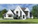 New construction home with a painted brick facade, gray trim and lush green front yard at 65 Firefly Overlook, Pittsboro, NC 27312