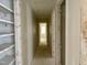 Long hallway featuring multiple doorways, built in shelving and light-filled room at the end at 65 Firefly Overlook, Pittsboro, NC 27312