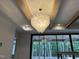 Living room with exposed beam ceiling, modern chandelier, and sliding glass doors to back patio at 65 Firefly Overlook, Pittsboro, NC 27312