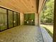 Covered patio with brick fireplace, and view of treelined backyard at 65 Firefly Overlook, Pittsboro, NC 27312