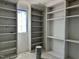 Bright walk-in closet with shelves, a window, and natural light during construction at 65 Firefly Overlook, Pittsboro, NC 27312
