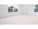 Bright bedroom with neutral carpeting, white walls, white trim, and two large windows at 1873 Old Fields Blvd, Haw River, NC 27258