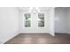 Bright dining room with hardwood floors, modern chandelier, large windows, and white trim at 1873 Old Fields Blvd, Haw River, NC 27258