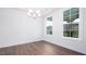 Bright dining room featuring hardwood floors, white trim, a chandelier, and two large windows at 1873 Old Fields Blvd, Haw River, NC 27258