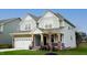 Charming two-story home with a well-maintained lawn, a two-car garage, and stone and wood accents at 1873 Old Fields Blvd, Haw River, NC 27258