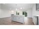 Open-concept living space with a kitchen island, stainless steel appliances, and access to the backyard at 1873 Old Fields Blvd, Haw River, NC 27258