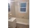 A bathroom featuring white tiles and a bathtub with a window providing natural light at 1202 N Duke St, Durham, NC 27701