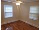 An empty bedroom featuring hardwood floors, a ceiling fan, and two windows for ample light at 1202 N Duke St, Durham, NC 27701