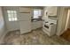 A bright kitchen with white cabinets and appliances, featuring a door to the outside at 1202 N Duke St, Durham, NC 27701
