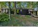 Dark-colored house with green door and wooded setting at 9601 Leslie Dr, Chapel Hill, NC 27516