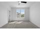 Spacious bedroom with neutral carpet, ceiling fan, and large windows at 2337 E Main St, Durham, NC 27703