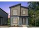 Charming two-story home with a modern door, neutral siding, and neat landscaping at 2337 E Main St, Durham, NC 27703