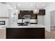 Modern kitchen features an island with seating, stylish pendant lights, and stainless appliances at 2337 E Main St, Durham, NC 27703