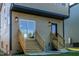 Rear elevation showing dual wooden staircases with black framed doors and exterior lighting at 2337 E Main St, Durham, NC 27703
