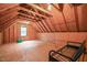 Unfinished attic space with wood beams and a small window at 3015 Old Raleigh Rd, Apex, NC 27502