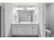 Bathroom with double sink vanity, white cabinets, and modern lighting fixtures at 553 Eversden Dr, Zebulon, NC 27597