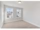 Bright bedroom with neutral carpet, white walls, and two windows offering neighborhood views at 553 Eversden Dr, Zebulon, NC 27597