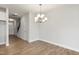Elegant dining room area with hardwood floors, a modern chandelier, and a view of the entryway at 553 Eversden Dr, Zebulon, NC 27597