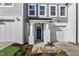 Charming townhome featuring a gray and white exterior, garage, and covered porch with a teal-colored front door at 553 Eversden Dr, Zebulon, NC 27597