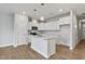 Modern kitchen with white cabinets, a kitchen island, stainless steel appliances, and hardwood floors at 553 Eversden Dr, Zebulon, NC 27597