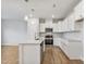 Modern kitchen featuring white cabinets, stainless steel appliances, a large island, and stylish pendant lighting at 553 Eversden Dr, Zebulon, NC 27597