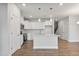 Modern kitchen featuring white cabinets, stainless steel appliances, a kitchen island, and wood floors at 553 Eversden Dr, Zebulon, NC 27597