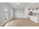 Open-concept living space with kitchen featuring white cabinets, stainless steel appliances, and hardwood flooring at 553 Eversden Dr, Zebulon, NC 27597