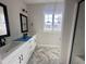 Bathroom featuring double sinks, vanity, and black accents with window for natural light at 614 Tuscany Cir, Princeton, NC 27569