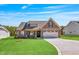 Charming single-Gathering home with a manicured lawn, stone accents, and a two-car garage at 258 Thistle Ct, Sanford, NC 27332