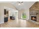 Open-concept living room with a stone fireplace, vaulted ceilings, and access to the backyard at 258 Thistle Ct, Sanford, NC 27332