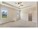 Spacious main bedroom with tray ceiling, ceiling fan, and bright windows at 258 Thistle Ct, Sanford, NC 27332