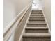 Carpeted staircase leading to upper level with neutral wall color and wood railing at 258 Thistle Ct, Sanford, NC 27332
