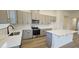 Modern kitchen featuring gray cabinets, stainless steel appliances, tile backsplash, and a center island with quartz countertops at 508 John Stark Dr, Fuquay Varina, NC 27526