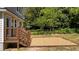View of the home's private backyard patio, featuring a small deck, stone base, and mature landscaping at 605 Quarry St, Raleigh, NC 27601