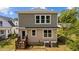 The back of the home with a wood staircase, back door, vinyl siding, and a gravel patio at 605 Quarry St, Raleigh, NC 27601