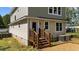 A close up of the back of the home with a wood staircase, back door, and vinyl siding at 605 Quarry St, Raleigh, NC 27601