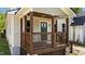Close up of the covered front porch with stained wood columns and a bright green front door at 605 Quarry St, Raleigh, NC 27601
