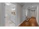 Hallway view to bathroom with white cabinetry, and hardwood floors at 605 Quarry St, Raleigh, NC 27601