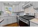 Bright kitchen featuring white cabinets, stainless appliances, and marble backsplash at 605 Quarry St, Raleigh, NC 27601