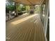 View of new covered deck with wood flooring, fireplace, and large sliding glass doors at 217 Dublin Rd, Raleigh, NC 27609