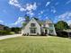 Charming new two-story home featuring a manicured lawn, lush landscaping, and elegant architectural details at 217 Dublin Rd, Raleigh, NC 27609