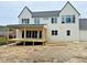 Rear exterior of new home with large windows, covered porch and unfinished back yard at 217 Dublin Rd, Raleigh, NC 27609